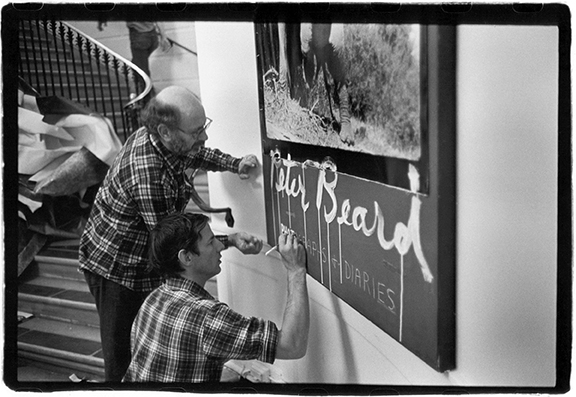 Installation designer Marvin Israel (left) and Peter Beard in the lobby of the International Center of Photography preparing for the exhibit The End of the Game
